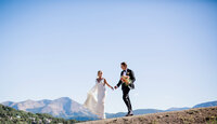 Wedding couple holding hands in mountains in Crested Butte