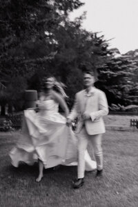 Bride and groom running while laughing