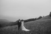 Bride and groom standing at the top of a mountain
