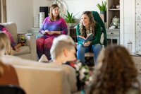 woman reading book to group that she's training