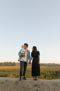 family standing with baby