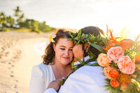 parents and high school senior laugh on the beach at sunset.