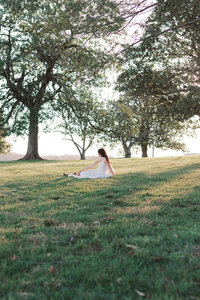 girl sits under trees at lakeshore park in knoxville tennessee