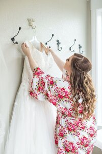 Bride hanging up wedding dress