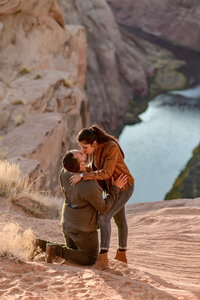 Man proposing to his partner at the edge of Horseshoe Bend, with the iconic bend in the Colorado River and breathtaking desert landscape in the background