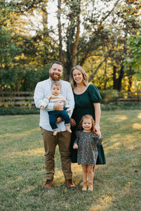 A family portrait with parents and two children looking at camera at St. Louis park