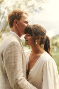 A vintage portrait of a wedding couple sharing their first kiss in Ohope. Photo captured by Eilish Burt Photography