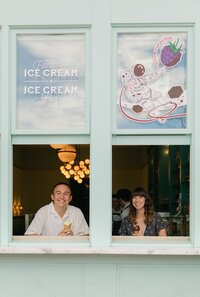 Couple sitting in the window of Sweet Cooie's ice cream shop in Denver
