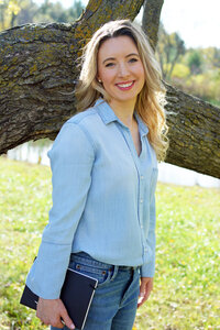 Katie Mohar, author of clean children's books, poses outdoors.
