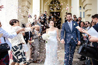 Couple walk out aisle with confetti