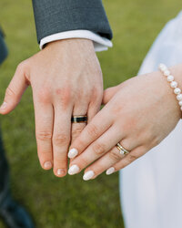 A couple showing their rings on their wedding day 