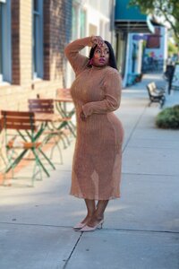 african american female author nakeia homer in a brown sweater dress and pink earrings