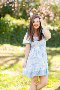 Holly smiling in a blue and white dress