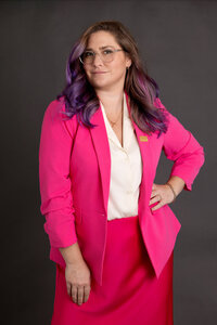 Branding headshot of a social media influencer and women's advocate in a bright pink suit, captured in a modern studio setting.