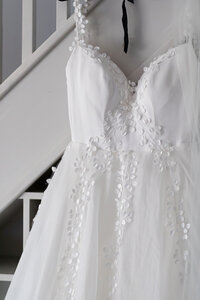 wedding dress hanging on a stair case