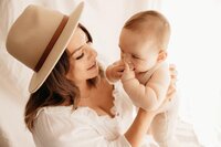 A mother holding her little baby during their family photoshoot