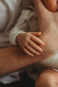 close up photo of a newborn babies hand grasping his dads hand