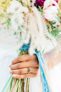 Closeup of a bride's hand holding her wedding bouquet