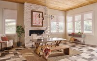 Shuttered windows in a rustic dining room with a fireplace