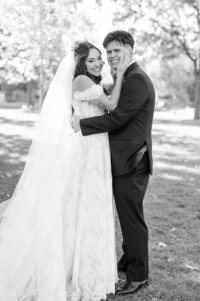 Bride and groom laugh at each other under the veil.