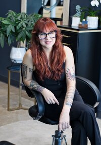 Headshot of hair stylist Hattie sitting in salon chair in Dallas modern chic hair salon.