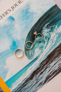 Bride and groom wedding rings flat lay photo taken by skilled maine wedding photographer