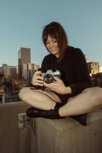 Kmm photography girl sitting on cement and holding film camera