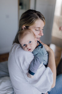 newborn-baby-over-mums-shoulder-looking-at-camera