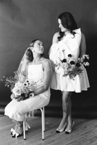 two brides looking at each other, one is sitting