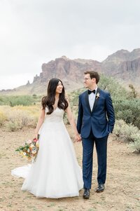 The Paseo Weddings Bride and Groom holding hands with mountain view