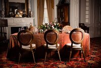 table and chairs with velvet table cloth and large floral centerpiece at Rippavilla Mansion