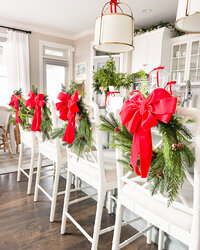 christmas wreaths tied to barstools