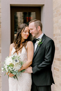 bride and groom standing close and touching foreheads