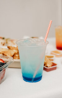 iced blue drink with red and white pinstripe straw