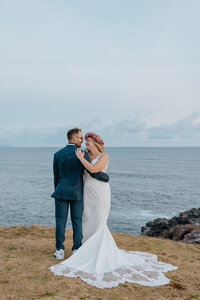 a husband and wife walking along the beach at white rock beach in Maui just after getting married in one of our all exclusive elopement packages