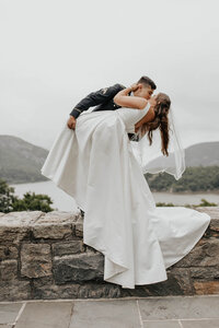 A bride and groom dipping and kissing posing for a photo