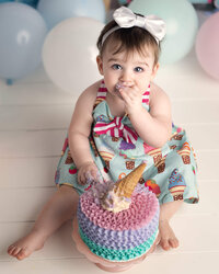Adorable young child wearing blue dress for her cake smash portrait session
