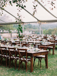 Brown reception tables under a clear tent