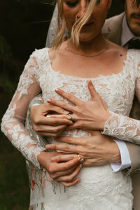 bride and groom holding their wedding bands