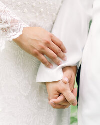 Wedding couple holds hands during their intimate