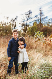 two small children hugging in a field