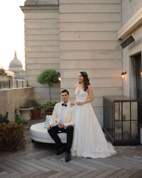 bride and groom pose on the rooftop of the ned London with st Pauls cathedral in the background at golden hour during their chic london wedding