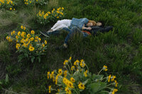 couple lying in the yellow wildflowers in kelowna spring time
