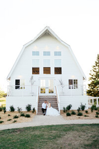 Newlyweds sitting on the  stairs of the romantic white Ivory North Co wedding venue in the intimate quiet moment, captured  Toly Dzyuba Photography | Minnesota wedding photographer