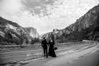 Black and white photo of a joyful couple eloping on a sandy beach at Lake Tahoe, with the groom dipping the bride in a playful embrace by the water.
