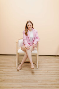Woman posing for photo wearing pink blazer