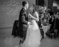 Wedding guests dance underneath ambient market lighting