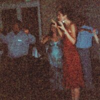 a woman in a red dress dancing with a group of people