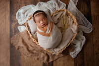 newborn baby posed in bamboo heart basket, photography studio in Hamilton, ON