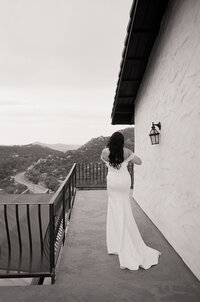 Black and white film photo of a groom reading a handwritten letter before the wedding ceremony — a quiet, intimate moment captured by a film wedding photographer.